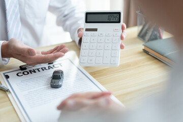 Fototapeta premium The selling agent informing his client about the expense by showing it on the calculator