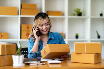 Starting Small business entrepreneur SME freelance,Portrait young woman working at home office, BOX,smartphone,laptop, online, marketing, packaging, delivery, SME, e-commerce concept