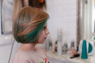 Teenage girl with colored green hair in a bob hairstyle