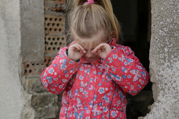Portrait of little sad girl in ruined building. Refugees, war crisis, humanitarian disaster concept.