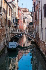 Fototapeta na wymiar Kanal in Venedig mit Boot und Spiegelung im Wasser