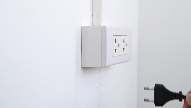 Hand remove Electric plug on socket. Electrical equipment, electrical wires and power strips in the house. wrong or unsafe
