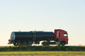 Petrol cargo truck driving on highway hauling oil products. Delivery transportation and logistics concept