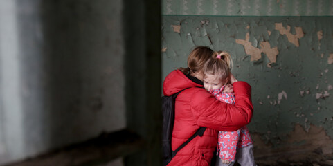 Mother and her daughter in destroyed buildng. War, refugees, war crisis concept.