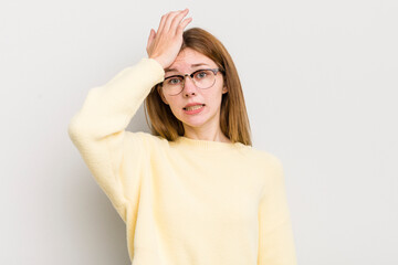 red head pretty woman raising palm to forehead thinking oops, after making a stupid mistake or...