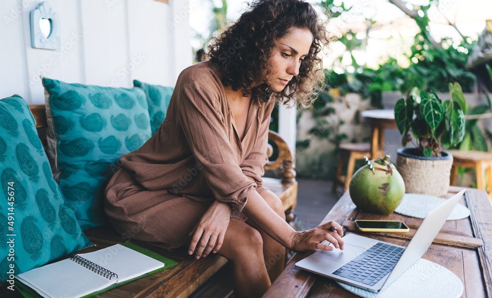 Aufkleber skilled caucasian woman with textbook searching media content for doing graphic design via applicati