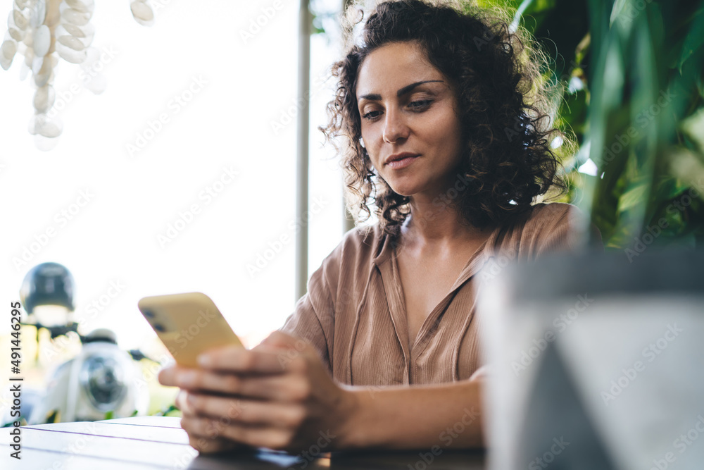 Poster caucasian female blogger using cellular application for making online booking on mobile website, mil