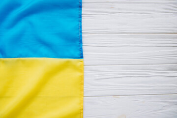 Ukrainian flag on a white wooden background.