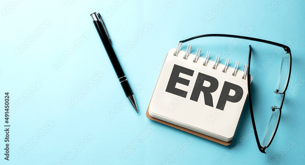 Aufkleber erp text written on a notepad on the blue background