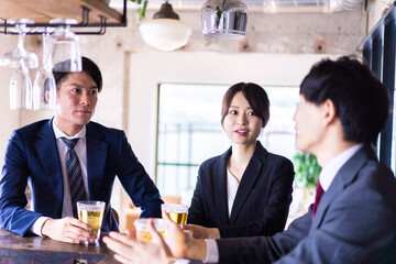 バーでお酒を飲む男女の会社員