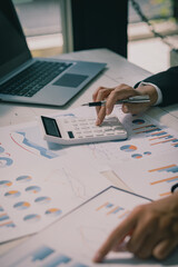 Businessman holding pen to analyze financial markets Young man works in office using laptop while...