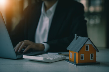 A real estate agent offers his clients an interest rate contract after signing the contract. Real estate or rental property ideas while signing an agreement on the clipboard at a wooden table.