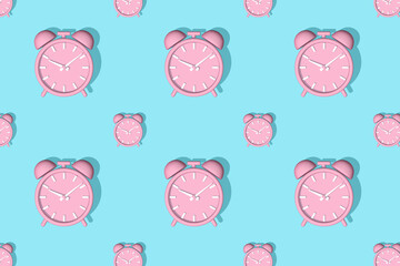 Pink alarm clocks big and small with shadow on blue background. Set. Seamless texture pattern. 3D illustration.