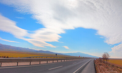 Asphalt curve road with amazing cloudy sky panorama in countryside on sunny day