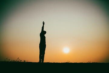 Silhouette of the woman standing lonely at the river during beautiful sunset