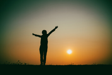 Silhouette of the woman standing lonely at the river during beautiful sunset