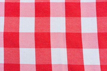 Close up and top view of checkered pattern fabric with square red and white shows detail of weave surface for table cloth for dining in restaurant. It is beautiful background for retro and vintage.