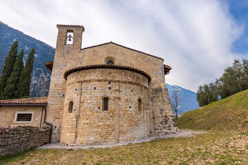 Fototapeta na wymiar Small ancient church of San Lorenzo Martire (St. Lawrence Martyr) in Romanesque Gothic style, XII century. Tenno village, Trento province, Trentino Alto Adige, Italy, Europe.