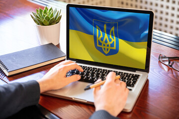 Support Ukraine, donate help Ukrainian people. Flag on computer laptop screen
