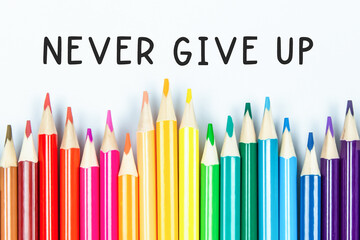 “Never give up” writing with color pencil background