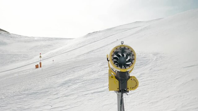 Snowmaking machine, snowgun, snow cannon at ski resort Livigno, Italy. Snowmaking is used at ski resorts to supplement natural snow. Machine gun for production of artificial snow. 4k footage video