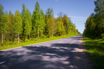 Obraz premium Beautiful spring landscape of rural area with asphalt road. Seasonal scenery of Northern Europe.