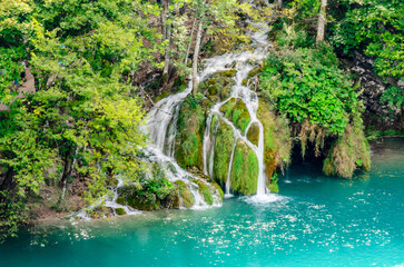 Beautiful Waterfall Cascade in Plitvice Lakes National Park, Croatia. Green Natural Environment with Waters Falling into the Blue Lake through Rocks and Trees