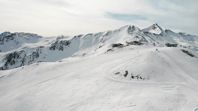 People snowboarding skiing at ski resort. Skiers, snowboarders riding snowy mountain slope. Outdoor winter sport and scinery panoramic view. Aerial footage 4k