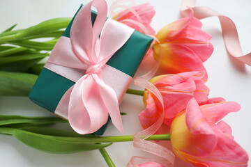 greeting card layout. a bouquet of pink tulips and a gift box with a pink bow 