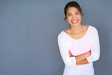 Motivate yourself or no one will. Cropped shot of a sporty young woman standing with her arms folded against a grey background. © C S W/peopleimages.com