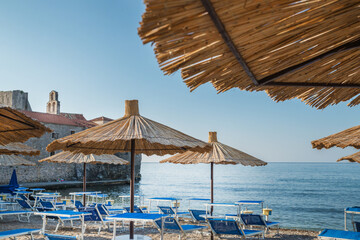 Summer vacation season, sandy beach with umbrellas.