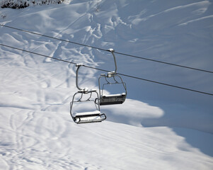 Two chair-lift with snowdrift in sun morning