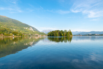 Fototapeta na wymiar Lake of Pusiano, Italy. In the center the Isola dei Cipressi (Cypress Island) and on the left the town of Pusiano . Natural lake between the cities of Como and Lecco 