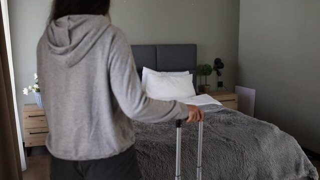 Young asian woman traveler with luggage looking at view in hotel room on vacation