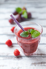 Fresh smoothie in a glass. Bright wooden background. Close up. 