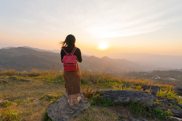 Naklejka premium Portrait of Asian woman, a tourist, travel on green mountain hills with fog on holiday vacation. Nature landscape background, Thailand. People lifestyle.
