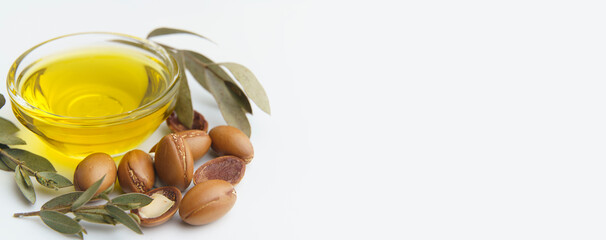 Argan seeds and oil isolated on a white background. Argan oil nuts with plant. Cosmetics and...