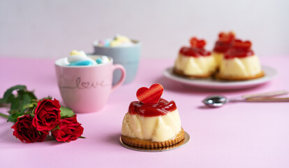 Bavarian cream pastry with strawberry jelly, two cups and roses
