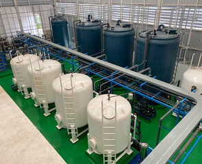top view of indoor watertreatment plant It has a blue fiberglass water tank and a white steel filter tank system. It has a cable trough and a blue steel base. - obrazy, fototapety, plakaty