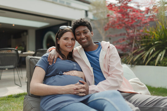 Portrait happy pregnant couple on patio