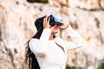 Una elegante mujer vestida con un traje blanco usando unas gafas de realidad virtual