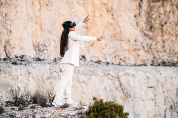 Una elegante mujer vestida con un traje blanco usando unas gafas de realidad virtual
