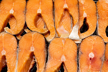 Salmon cut into pieces laid out for sale. A background of pieces of red fish close-up.