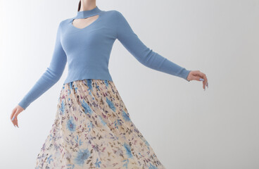 young girl in blue blouse  and pleated skirt on white background