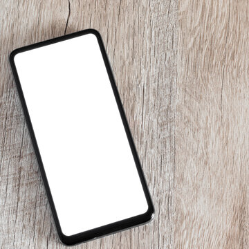 Square photo moke up smartphone on wooden background and copy space. A phone with a white screen on a flat lay desk.