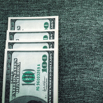 Square photo of hundred-dollar banknotes in green tinting. Fraud or theft of funds.