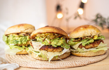 Close-up of tasty, home-made vegan hamburger on rustic table with fresh vegetables around.