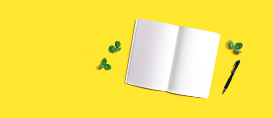 Blank notebook with shamrock leaves - flat lay