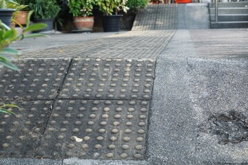 The sloped sidewalk is lined with braille blocks to provide added convenience and safety for the...
