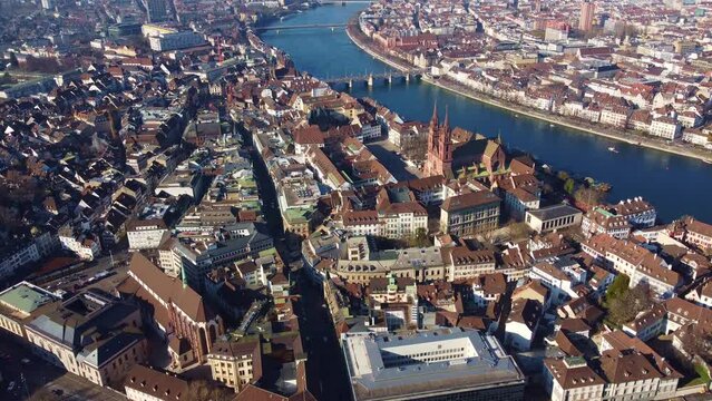 Aerial drone footage of the Basel old town with its cathedral along the Rhine river in Switzerland